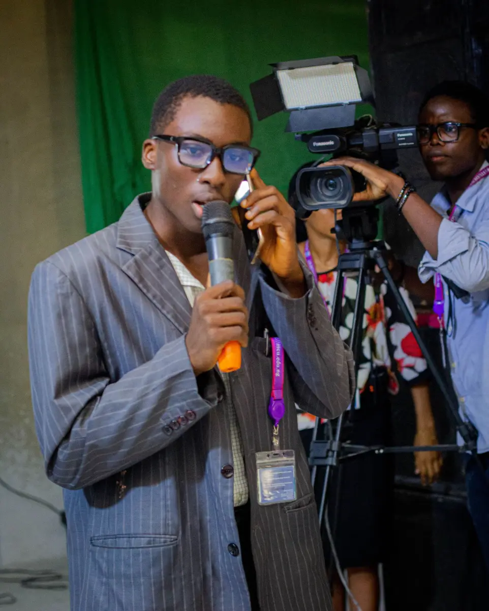 Boy wearing a suit and glasses acting in a drama session
