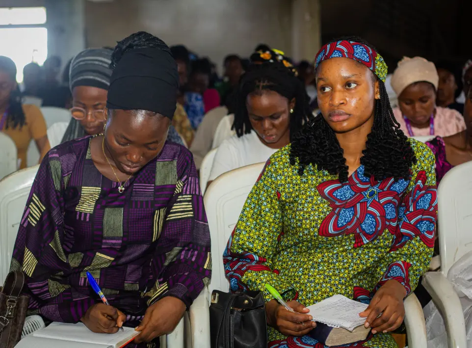 Students writing downs key points during a fellowship in Chapel of Praise 