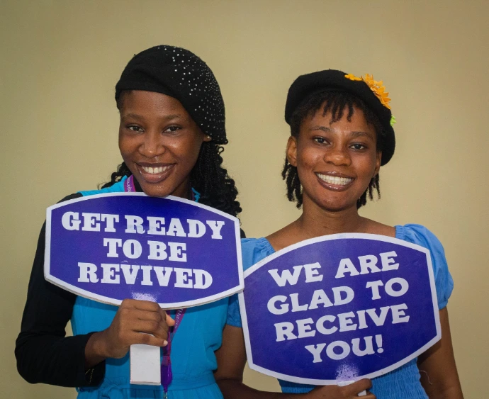 Two girls welcoming people to church